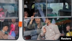 North Koreans look out of a tram as it passes by a department store in central Pyongyang. While some basic shopping is permitted, most North Koreans lived in poverty and rely on the state ration system for survival. 