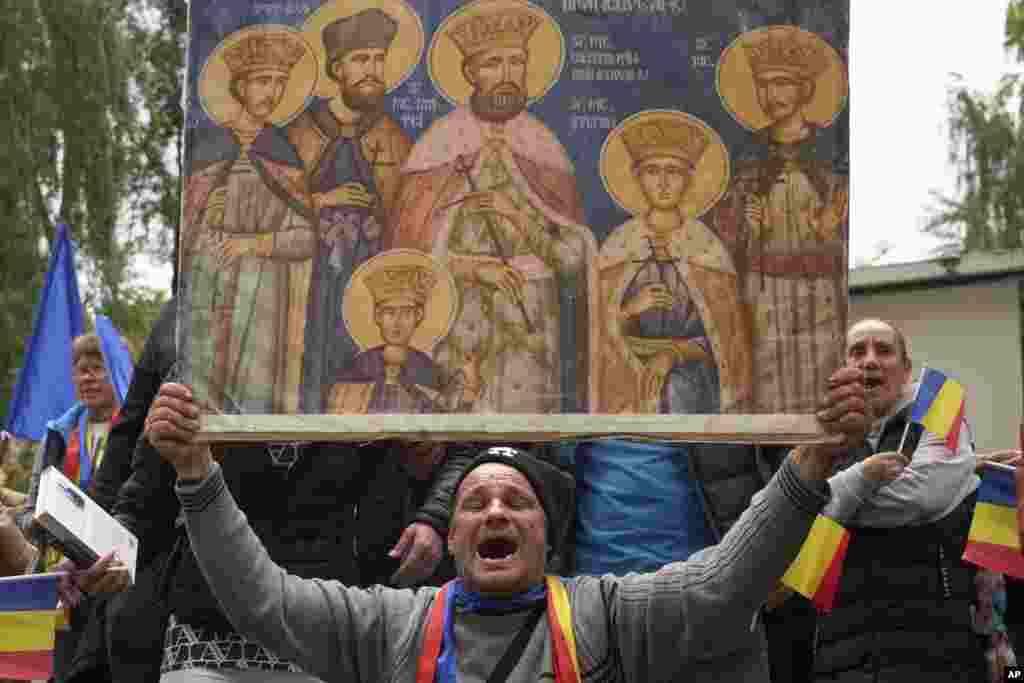 Supporters of Calin Georgescu, the controversial populist politician who won the first round of last year's annulled Romanian presidential election, chant slogans during his appearance at a prosecutor's office in Bucharest.