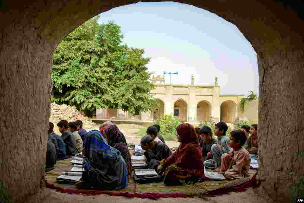 Afghan children attend a class at an open-air school in the Zhari district of Kandahar Province.