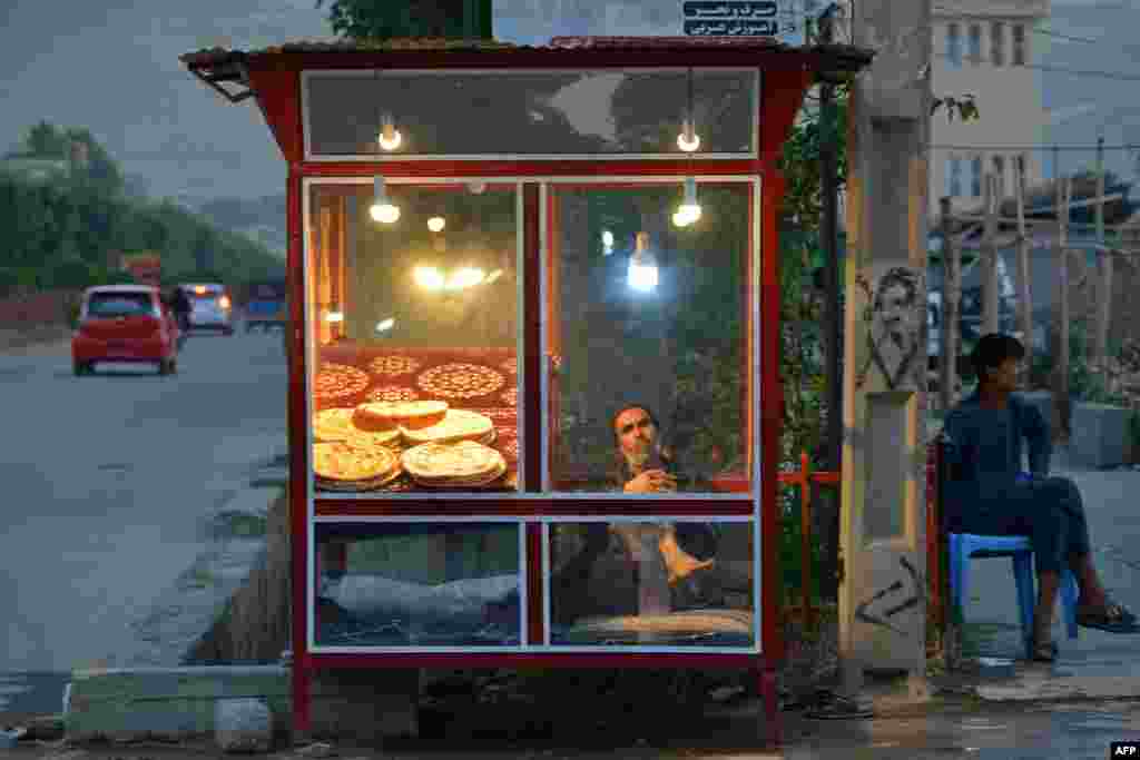 An Afghan vendor selling bread waits for customers along a street in the Fayzabad district of Badakhshan Province.