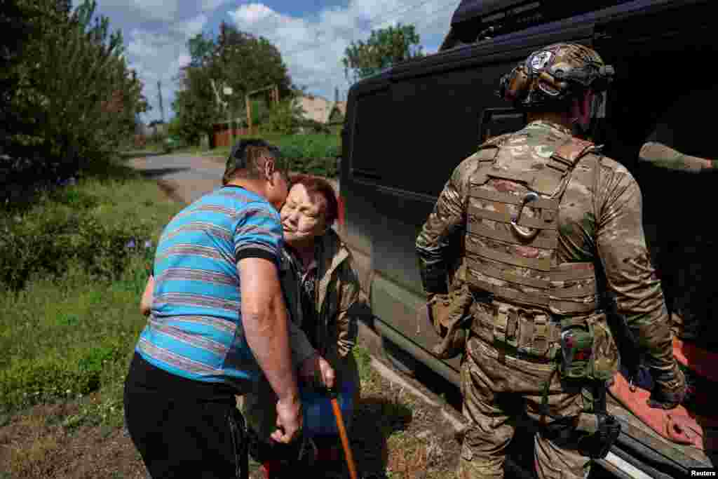 A son says goodbye and kisses his mother as Ukrainian police officers evacuate her from the frontline town of Pokrovsk in the war-torn Donetsk region.