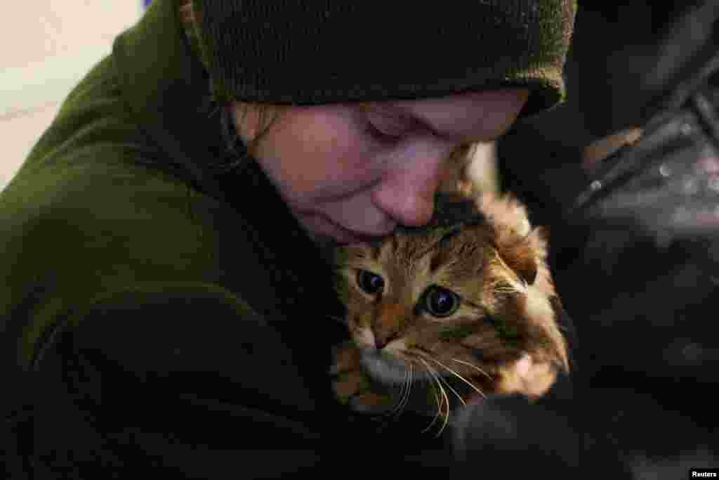 A Ukrainian evacuee from the eastern frontline city of Kostyantynivka, comforts her cat at a transit center in Pavlohrad.