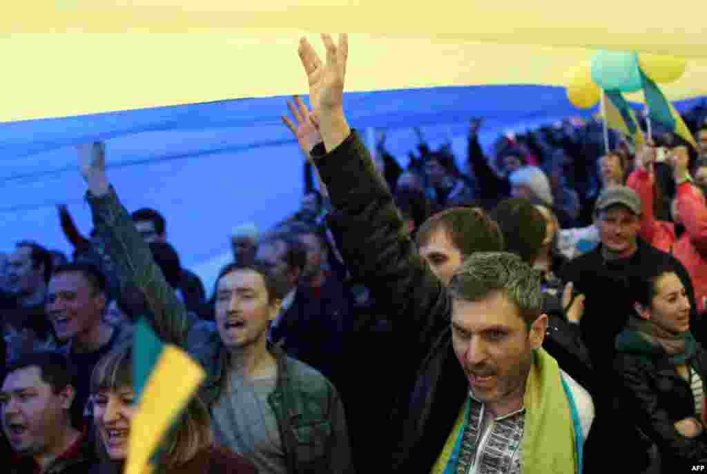 На проукраїнському мітингу в Донецьку розгорнули рекордний прапор. Площа полотна 1350 квадратних метрів. Прапор називають «донецьким», оскільки зшила його донеччанка, вдова шахтаря Марія Бєляткова. Донецьк, 17 квітня 2014 року