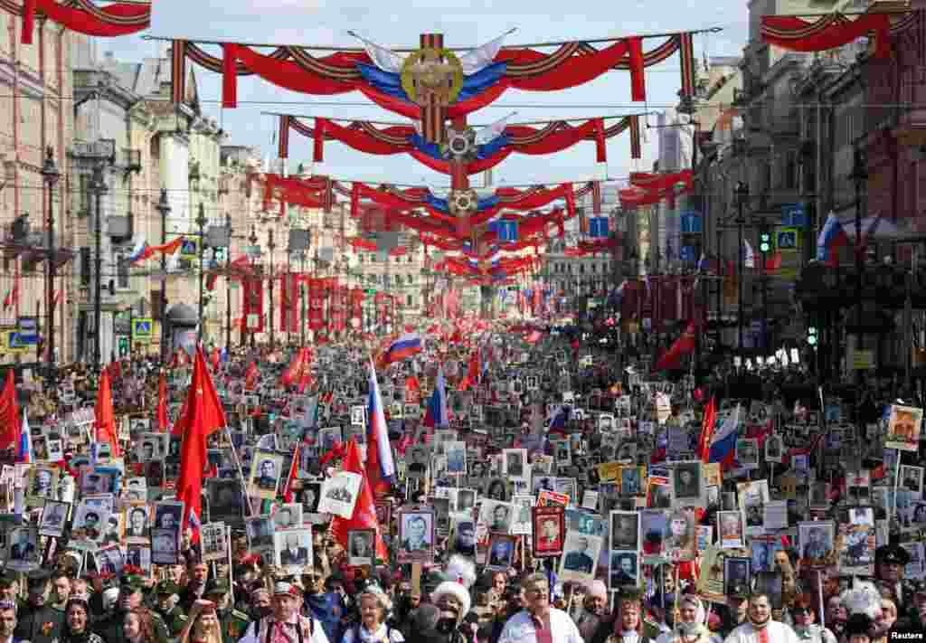 Participants carry portraits of people, including Red Army soldiers and veterans, during a march in St. Petersburg on Victory Day on May 9, when Russia marks the anniversary of the defeat over Nazi Germany in World War Two.