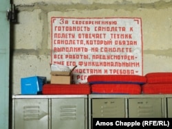 A Russian-language sign calling for aircraft technicians to be diligent hangs inside a Soviet hangar at Milovice.