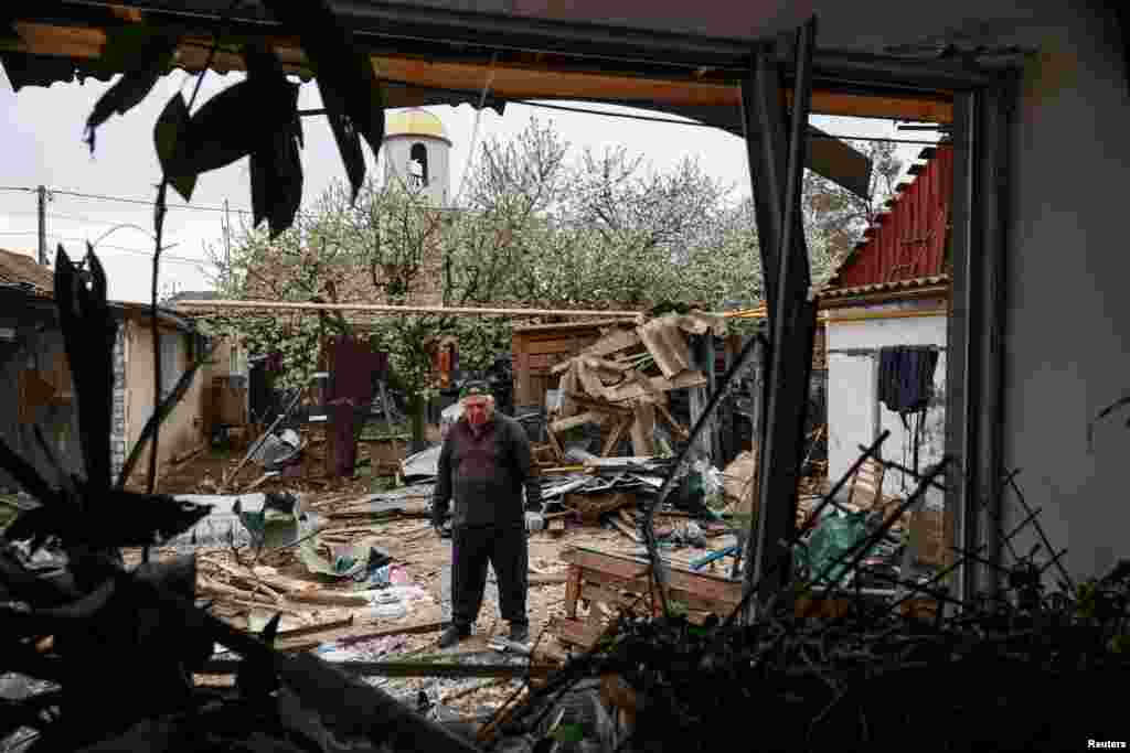 An Odesa resident stands in the backyard of his house, which was damaged during a Russian drone strike on the Ukrainian port city.