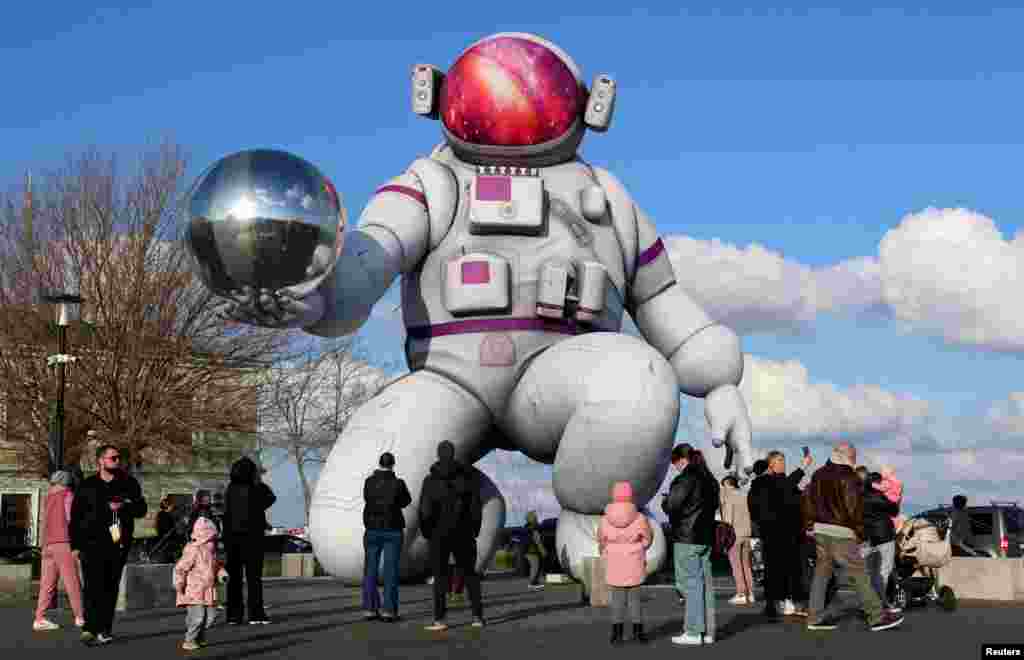 People gather on a square in the town of Yevpatoria in Ukraine's Russian-occupied Crimean Peninsula to look at a giant inflatable installed ahead of Cosmonautics Day on April 12.