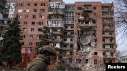 A Ukrainian soldier passes a residential building damaged by Russian military strikes in the frontline town of Pokrovsk on March 6.