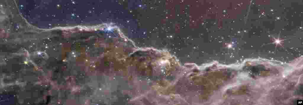 Deși ar putea fi o imagine a unor munți stâncoși, în imagine este reprezentată, în continuare, nebuloasa Carina, mai exact marginea unei mari cavități gazoase. 