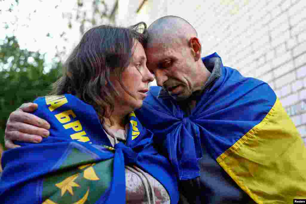 A Ukrainian prisoner of war embraces his wife as he returns home following the first stage of a prisoner swap with Russia, which began on May 23.