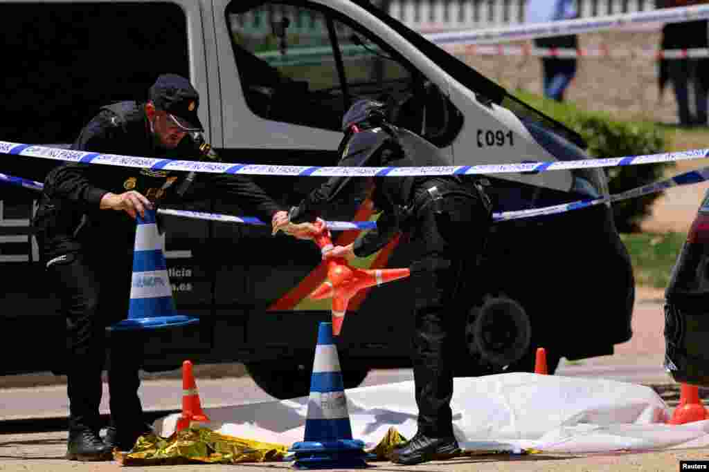 Spanish police officers work near the body of Andriy Portnov, a lawyer and former Ukrainian presidential adviser who was shot and killed by unidentified gunmen outside a school in Madrid on May 21.