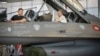 Președintele ucrainean Volodimir Zelenski (stânga) și premierul danez Mette Frederiksen stau într-un avion de luptă F-16 în hangarul bazei aeriene Skrydstrup din Vojens, nordul Danemarcei, pe 20 august.