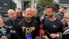 Andrew Tate (left) and his brother, Tristan (right), talk to reporters in front of a Romanian police station on March 24.