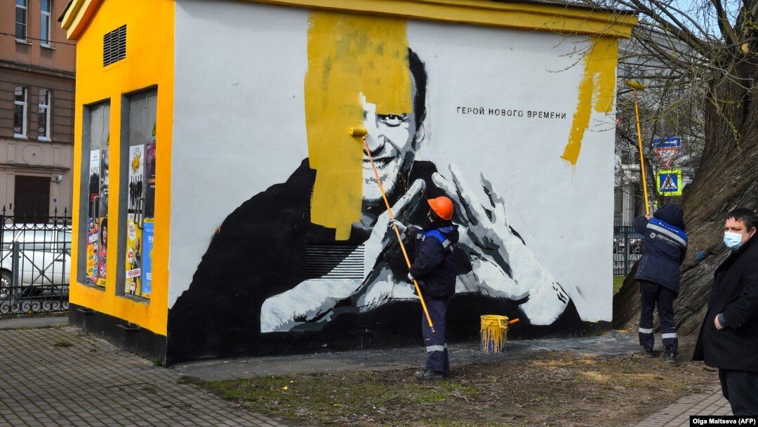 A worker paints over the mural of jailed Kremlin critic Aleksei Navalny in St. Petersburg.