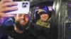 Евгениј Пригожин седи во воено возило и позира за селфи фотографија со локален цивил на улица во Ростов на Дон, Русија, 24 јуни 2023 година, пред да замине од штабот на Јужниот воен округ.