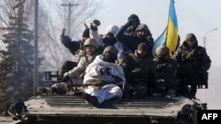 Ukrainian soldiers ride an armored personnel carrier as they leave the eastern Ukrainian city of Debaltseve on February 18.